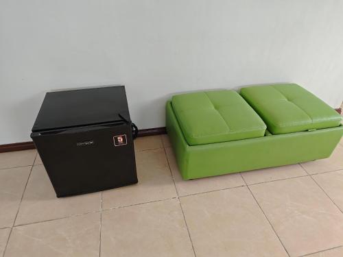 a green couch sitting next to a trash can at Best Inn Lahug in Cebu City