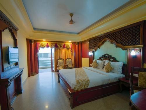 a bedroom with a bed and a flat screen tv at NRS Royal Palace in Puri