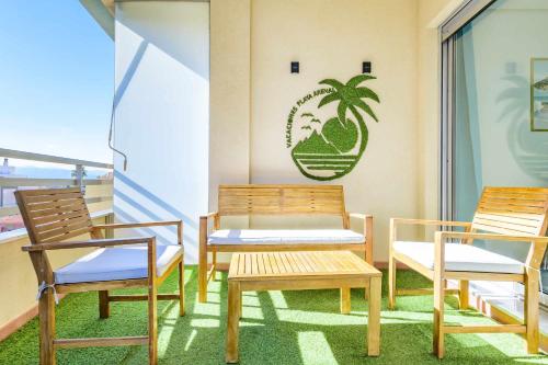 3 chaises et un banc sur un balcon dans l'établissement Apart Port Arenal con terraza y piscina, à Burriana