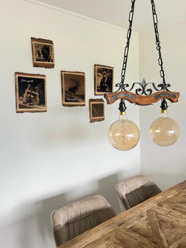 una sala da pranzo con lampadario pendente e immagini appese al muro di Apartment Annis Panoramablick Pool Sauna Tennis a Obertal