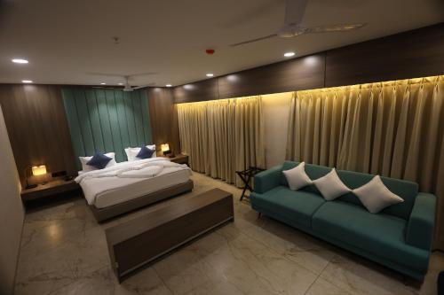 1 dormitorio con 1 cama y 1 sofá en Lords Eco Inn Navsari, en Navsāri