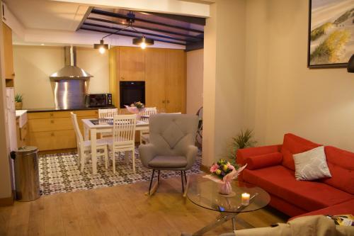een woonkamer met een rode bank en een tafel bij Maison familiale et cosy à la mer in Saint-Valery-sur-Somme