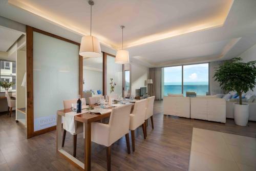 a dining room with a table and chairs and the ocean at Stunning Apartments Across My Khe Beach ! Rooftop Pool & Gym in Da Nang