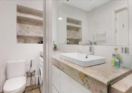 a white bathroom with a sink and a toilet at HD New Apartment in Tbilisi City