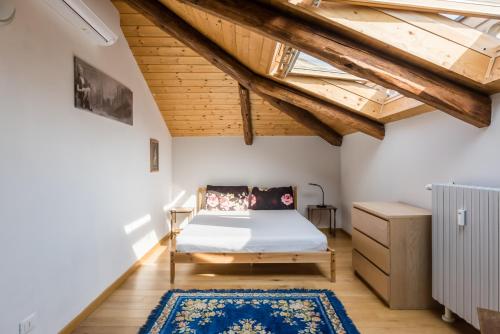 ein Schlafzimmer mit einem Bett und einer Holzdecke in der Unterkunft Liberty House - Vicina fermate Bus e Treno per Torino in Chieri