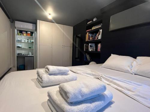 a bedroom with a bed with towels on it at So Athens - Studios and Apartments in Athens
