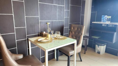 a dining room with a glass table and two chairs at Sky dome resotel - โรงแรมสกายโดม รีโซเทล in Bangkok