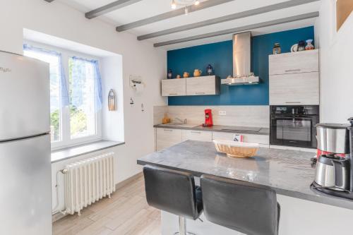 Il comprend une cuisine équipée d'un comptoir avec des chaises et d'un réfrigérateur. dans l'établissement Gîte de Loguivy de la Mer, à Ploubazlanec