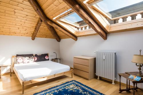 ein Schlafzimmer mit einem Bett und zwei Oberlichtern in der Unterkunft Liberty House - Vicina fermate Bus e Treno per Torino in Chieri