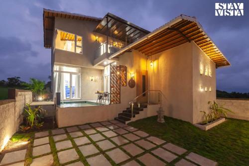 a villa with a swimming pool at night at StayVista's Coral Breeze with Plunge Pool, Games Room, Projector Setup, Proximity to Secluded Beach in Kolthare