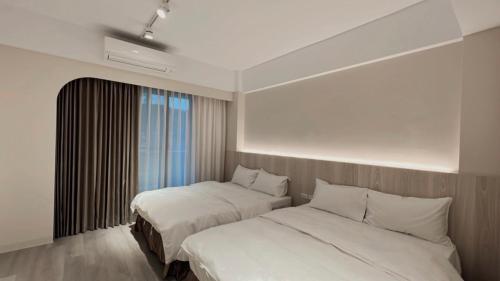 sypialnia z 2 łóżkami i oknem w obiekcie 玉井拱月民宿 w mieście Yujing