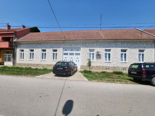 a brick building with two cars parked in front of it at Gold in Bela Crkva