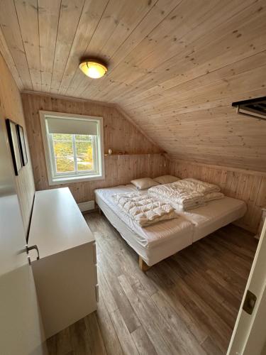 a bedroom with a bed in a wooden room at Vrådal Panorama - Flott hytte på toppen in Sinnes
