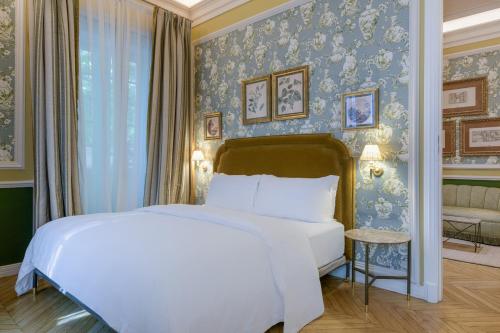 a bedroom with a bed and a blue wall at Santo Mauro, a Luxury Collection Hotel, Madrid in Madrid