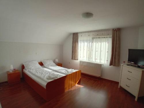 a small bedroom with a bed and a television at Casa Larisa in Vişeu de Sus