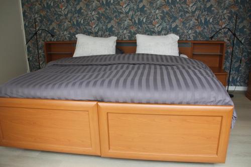 een houten bed met twee kussens erop bij tisOKE in Vught