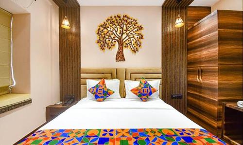 a bedroom with a bed with a tree on the wall at FabHotel Jalsa Residency New Town in Kolkata