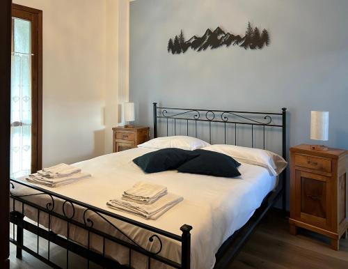 - une chambre avec un lit doté de draps et d'oreillers blancs dans l'établissement La Corte della Casera, à Cassina Valsassina