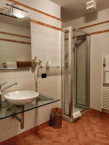 a bathroom with a glass sink and a shower at Aquazzurra Resort & Aparthotel in Cannobio