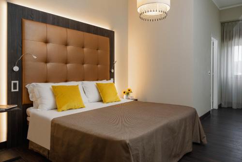 a bedroom with a large bed with yellow pillows at Hotel Lalla Beauty & Relax in Cesenatico