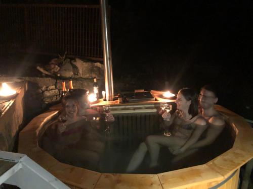 a group of people sitting in a hot tub at night at La Casa sulla collina del Castello in Breno