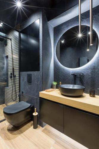 a bathroom with a sink and a toilet and a mirror at Egoist Boutique Suites in Veliko Tŭrnovo