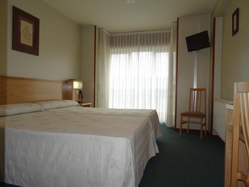 une chambre d'hôtel avec un lit et une fenêtre dans l'établissement Hotel Akelarre, à Saint-Jacques-de-Compostelle