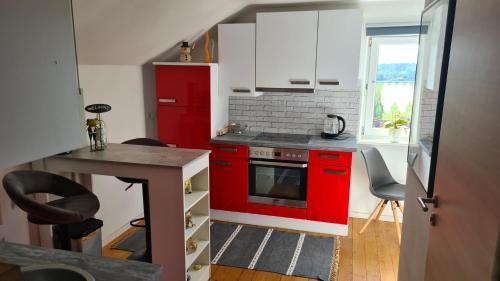 cocina con armarios rojos y estufa roja en Kleine Auszeit en Lauben