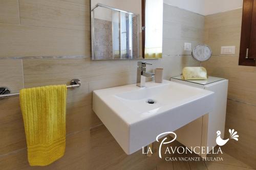 a bathroom with a white sink and a mirror at Case Vacanze La Pavoncella in Teulada