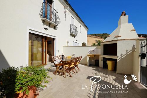 a view of the patio of a house with a table and chairs at Case Vacanze La Pavoncella in Teulada