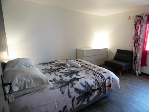 1 dormitorio con 1 cama y 1 silla en Chambres et Tables d'hôtes Chez Paul et Lydie en Cilaos