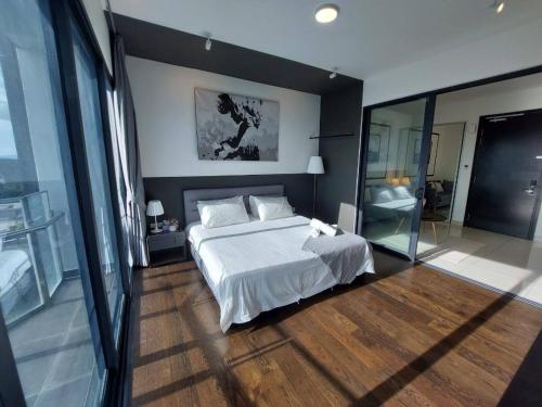 een slaapkamer met een wit bed en een grote spiegel bij Almas Suite Modern Comfy Studio House in Gelang Patah