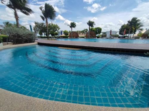 een zwembad met blauw water en palmbomen bij Almas Suite Modern Comfy Studio House in Gelang Patah