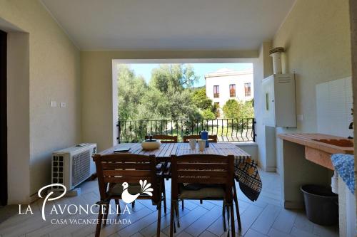 a dining room table and chairs in a kitchen with a window at Case Vacanze La Pavoncella in Teulada