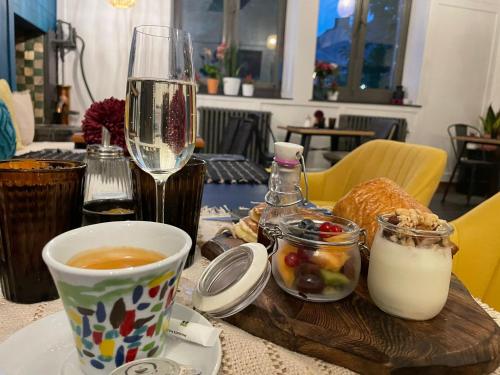 a table with a glass of wine and a plate of food at Hôtel Le Manoir in Marche-en-Famenne