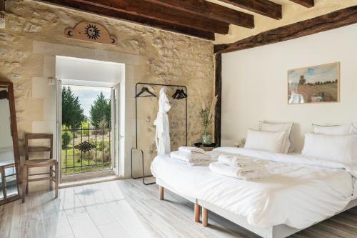 two beds in a room with a stone wall at Grande maison, piscine. 15 personnes. Sancerre in Gardefort