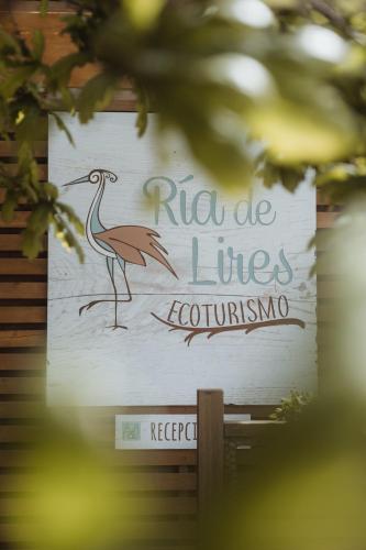 a sign with a bird on the side of a building at Cabañas de Lires in Lires