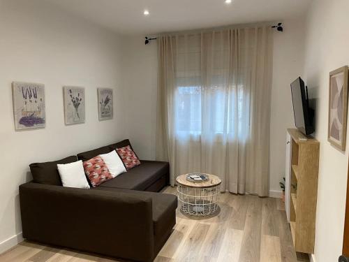 een woonkamer met een bank en een televisie bij Nice Apartment 2 Bedrooms Well Connected in Cornellà de Llobregat