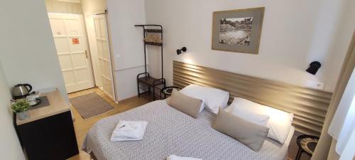 a small bedroom with a bed with a wooden headboard at Budapest Csaszar Hotel in Budapest
