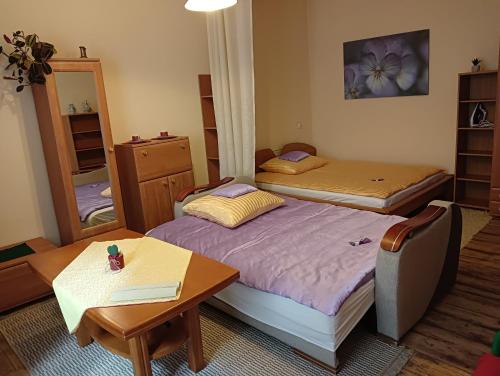 a small room with two beds and a table at Oficynka in Strzelce Opolskie