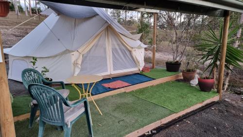 a white tent with a table and chairs on the grass at Linga Longa Spiritual Retreat in Curra
