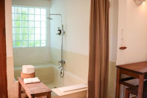a bathroom with a bath tub and a window at Sambor Village Hotel in Kompong Thom