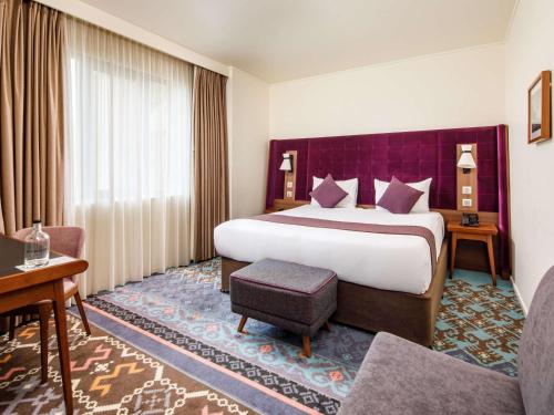 a hotel room with a large bed and a couch at Mercure London Bridge in London