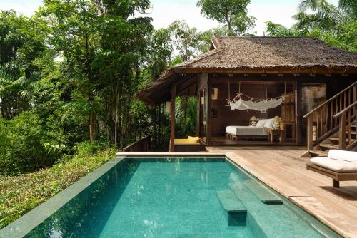 a villa with a swimming pool and a bedroom at Six Senses Yao Noi in Ko Yao Noi