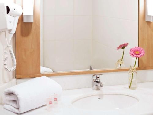 a bathroom with a sink and a mirror at ibis Novo Hamburgo in Novo Hamburgo