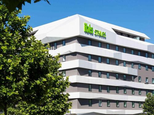 a tall white building with a big sign on it at ibis Styles Strasbourg Avenue du Rhin in Strasbourg