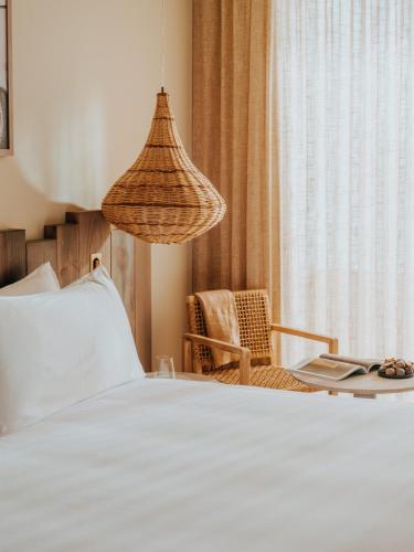 a bedroom with a bed and a chair and a lamp at Hyde Ibiza in Cala Llonga
