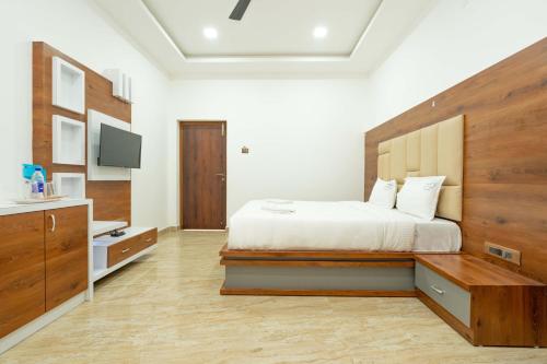 a bedroom with a large bed with a wooden headboard at HOTEL NATCHATHRA in Rāmeswaram