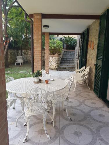 een witte tafel en stoelen op een patio bij B&B Ortensia in Cava deʼ Tirreni