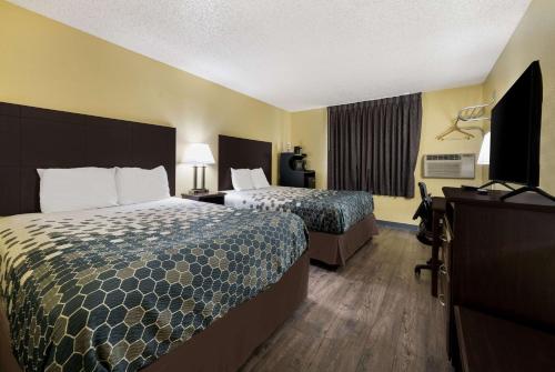 a hotel room with two beds and a desk at Econo Lodge Spotsylvania Town Center in Fredericksburg